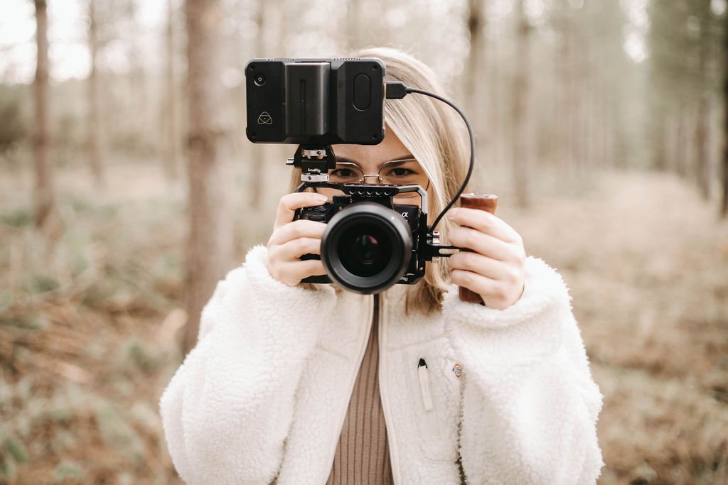 photographe de mariage tenant un appareil photo en forêt