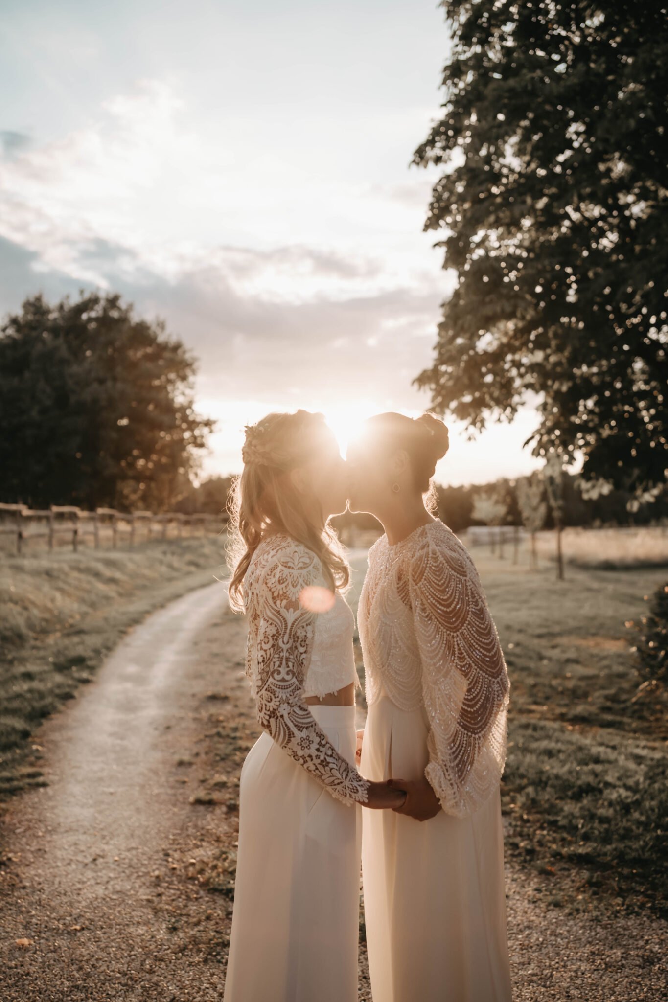 couple de mariées qui s’embrassent au coucher du soleil