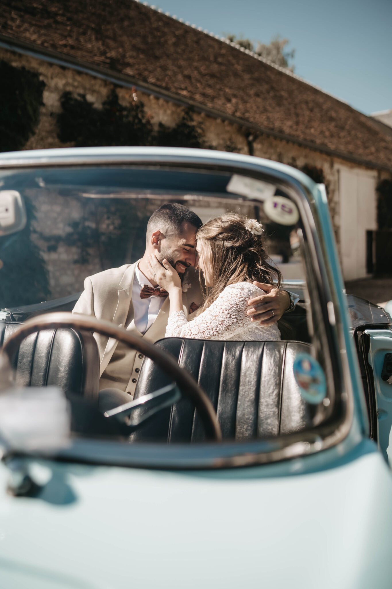 mariés dans une voiture ancienne pendant leur séance photo