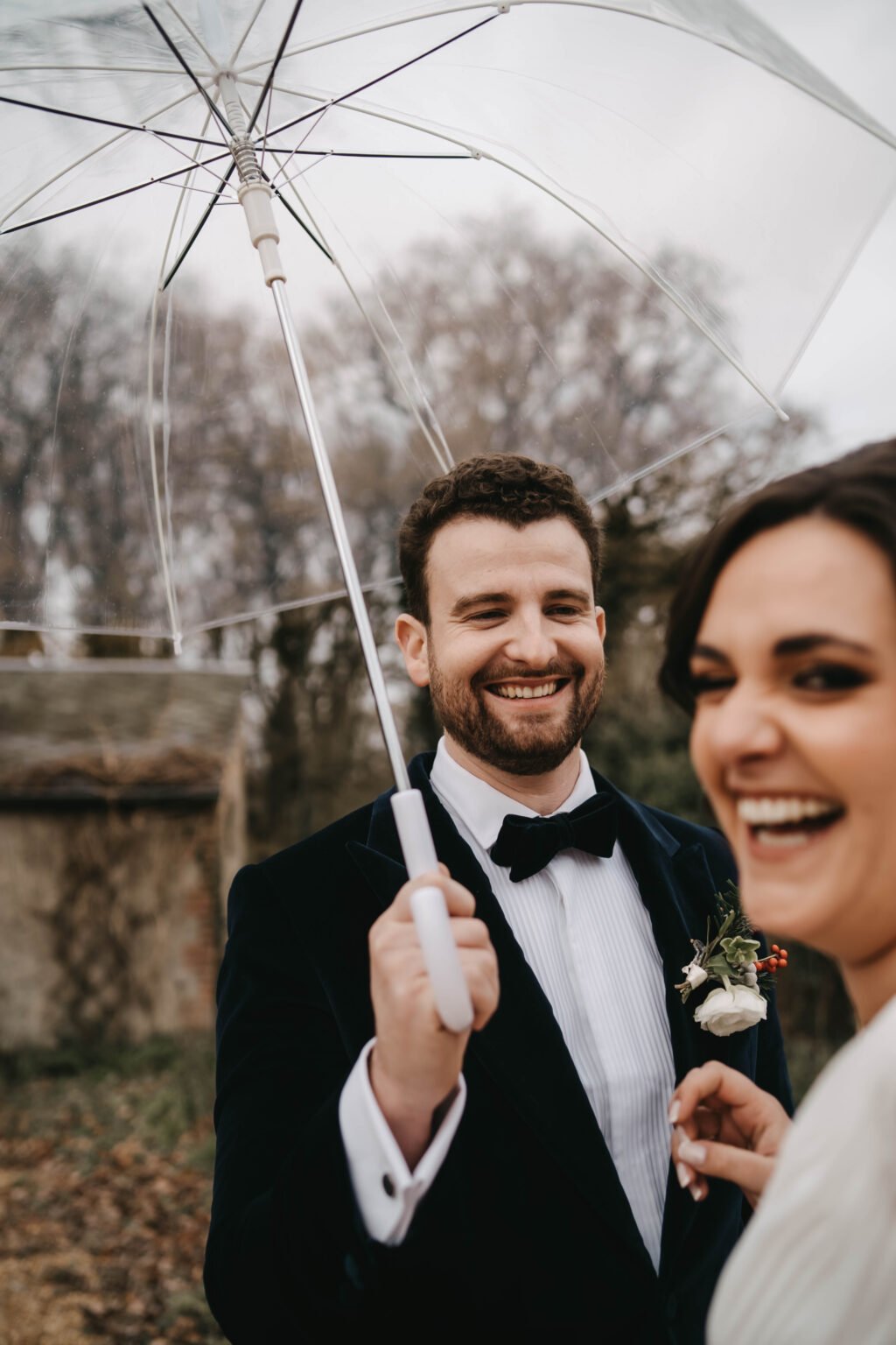 portrait de mariés souriants sous un parapluie