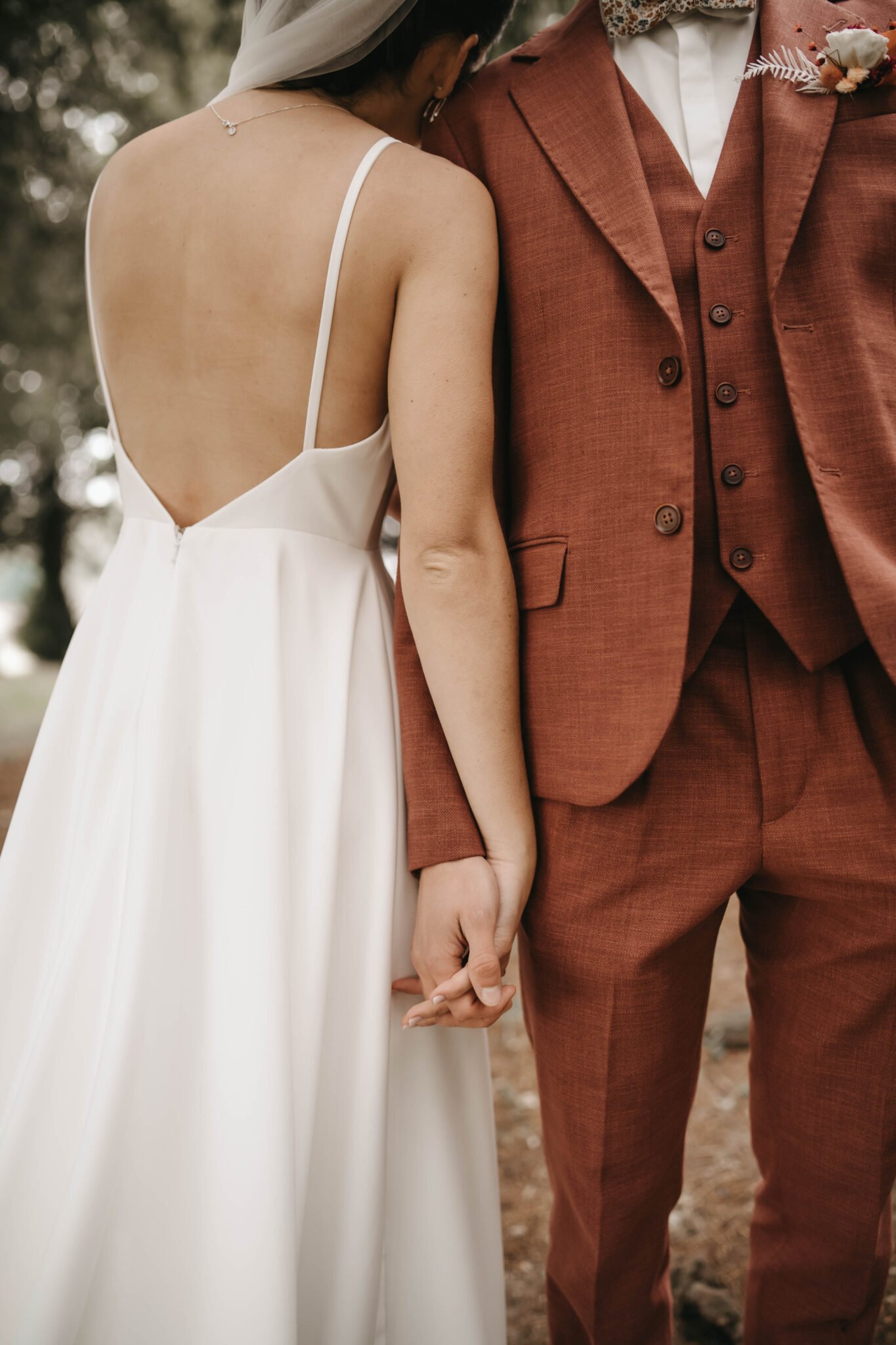 détail des mains des mariés tenant leurs mains pendant la séance photo
