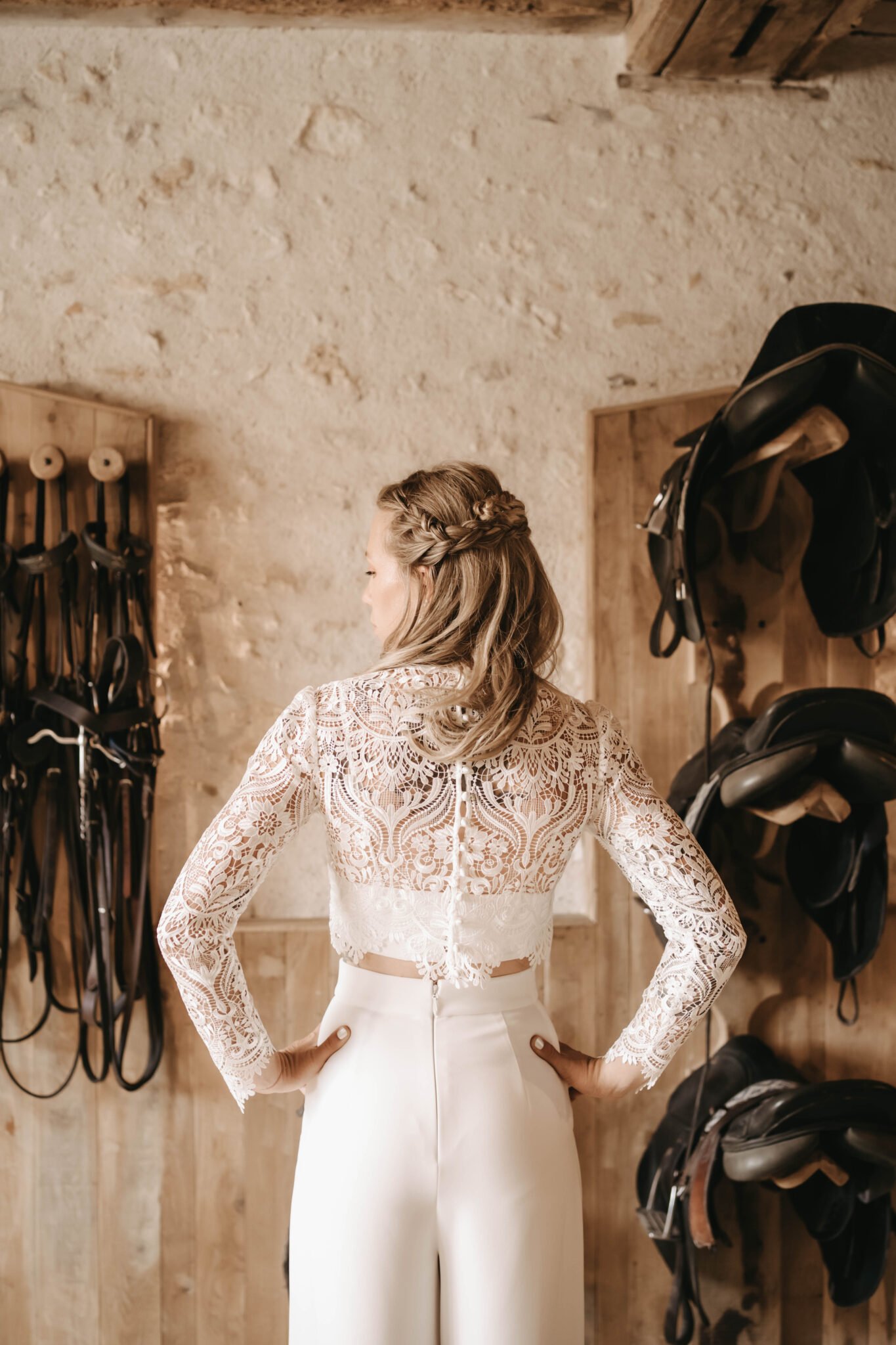 mariée de dos portant une tenue de mariage avec pantalon et haut en dentelle
