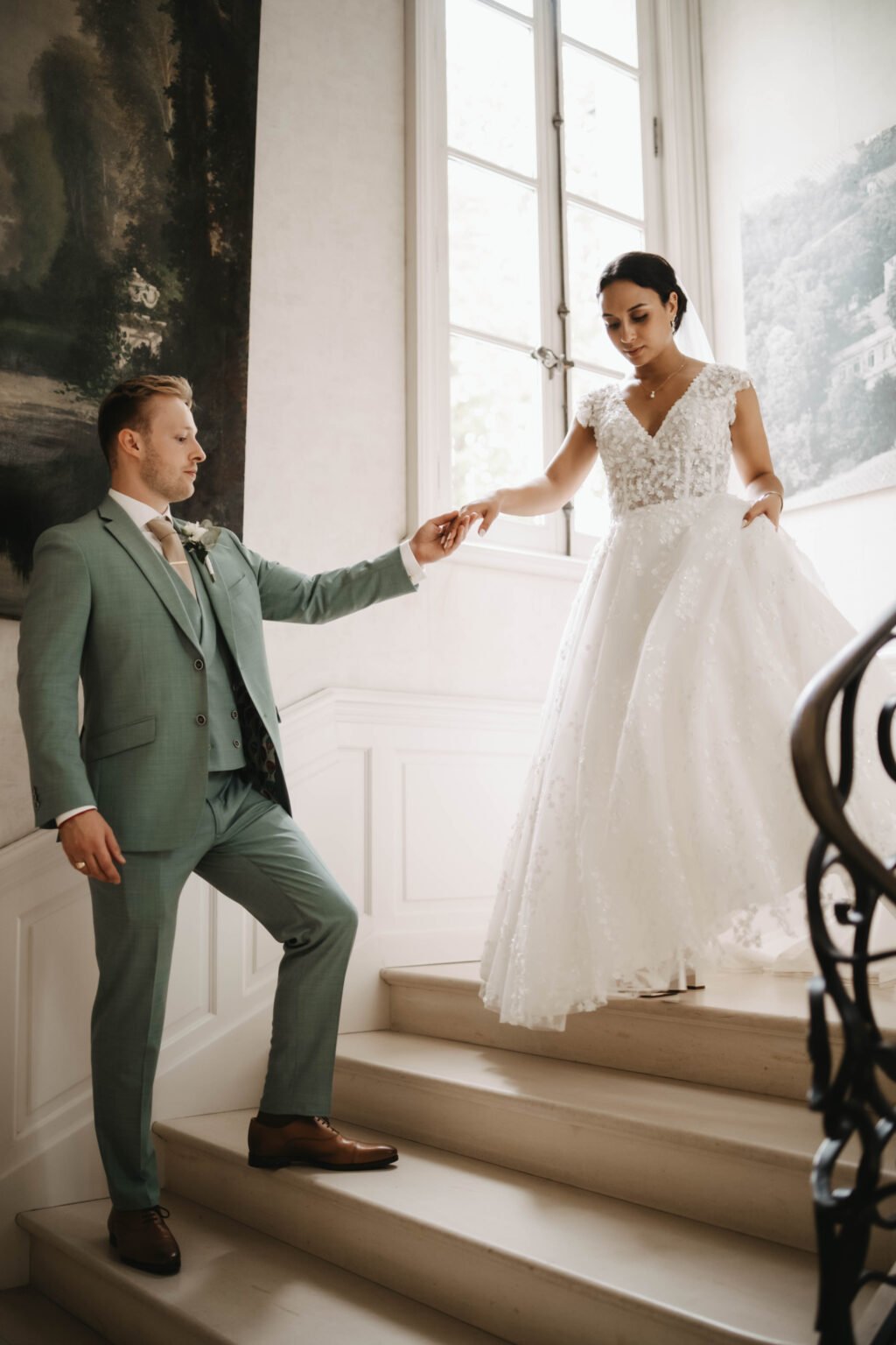 couple de mariés descendant un escalier dans un château