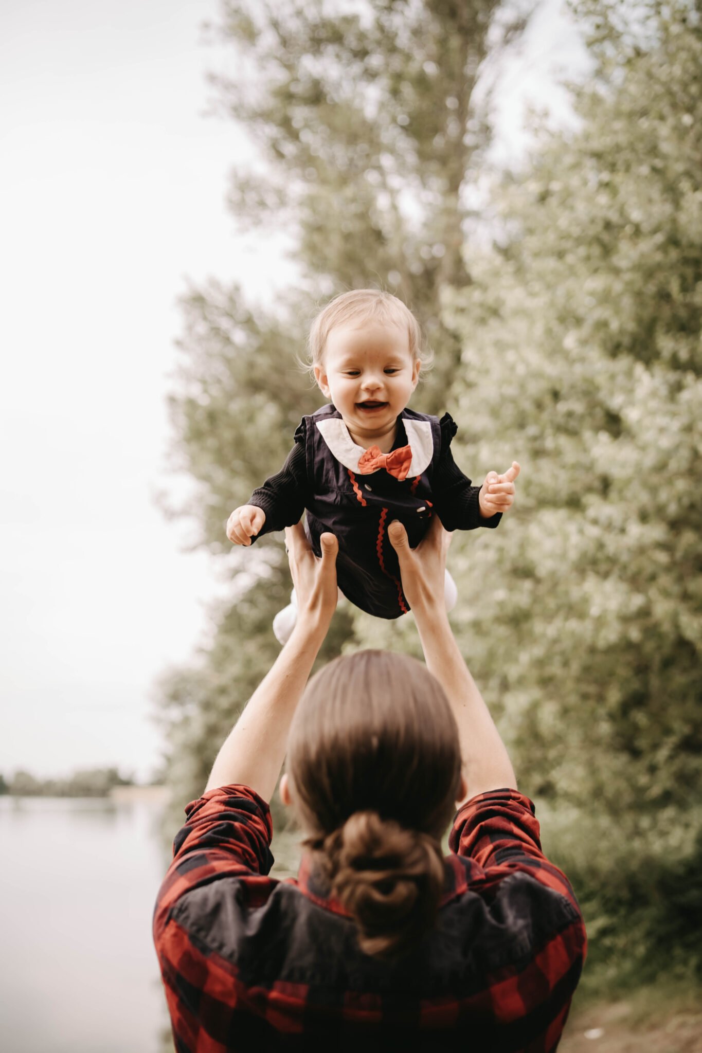 parent levant bébé en extérieur séance famille