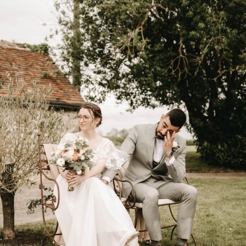 couple de mariés assis dans un jardin pendant leur mariage