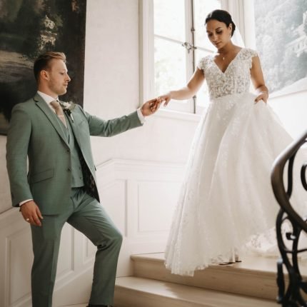 couple de mariés descendant un escalier dans un château